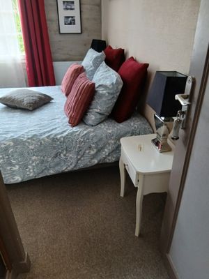une chambre avec un lit et une table de chevet sur laquelle se trouve une lampe