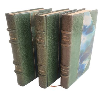 trois livres alignés sur une surface blanche
