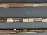 two old wooden canes with metal handles on a black surface