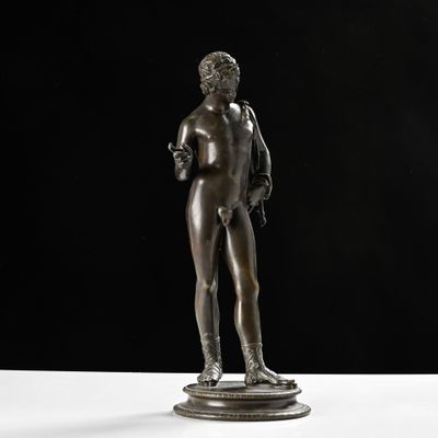 une statue en bronze représentant un homme debout sur un piédestal