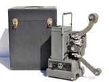 un vieux projecteur de cinéma posé à côté d'une boîte noire