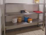 une étagère métallique sur laquelle sont posés des seaux, dans une cuisine