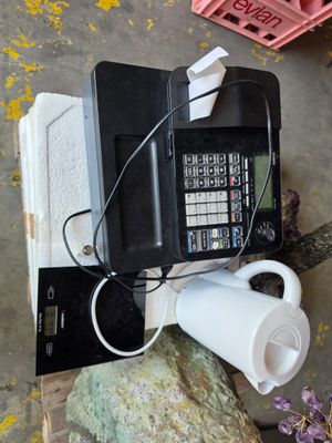 a cell phone sitting on top of a rock next to a coffee cup