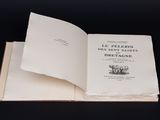 un livre ouvert posé sur une table noire, devant un fond noir