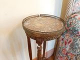 a small table with a marble top on a wooden floor