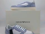 une paire de baskets bleues et blanches posée sur une boîte