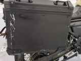 a black motorcycle with a black case on the back of it