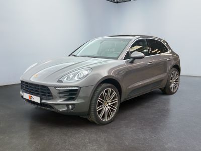 Une Porsche Cayenne grise est garée dans un showroom.