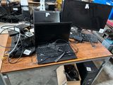a desk with two computers and a keyboard on it