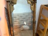 un miroir posé par terre à côté d'une étagère
