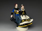 figurine of a man and a woman sitting on top of a chair