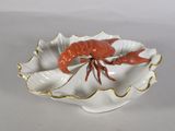 a white plate with a red lobster on it