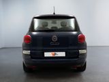 the back end of a small blue car in a white room
