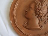 a brown plaque with a woman ' s head on it