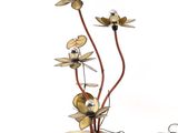 a vase with flowers made of metal on a table