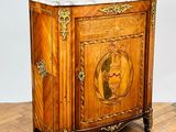 an antique wooden cabinet with a marble top on a parquet floor