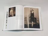 an open book with a black and white photo of a woman in a dress