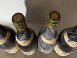 four bottles of wine are lined up on a table