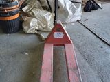 a fork lifter sitting on the floor in a garage