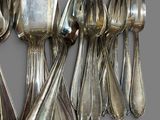 a lot of silver spoons and forks on the table