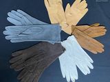 four pairs of leather gloves are arranged in a circle on a black surface