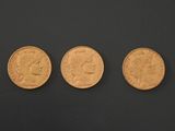 three different types of gold coins on a black surface