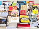 a lot of books that are stacked on top of each other