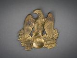 un aigle doré tenant une balle dans son bec