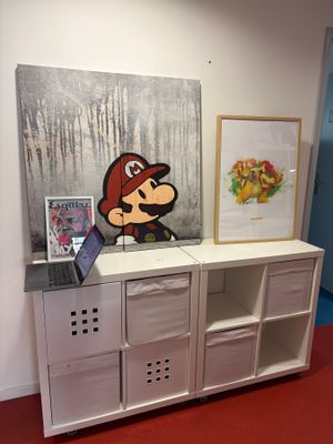 un tableau accroché au mur derrière une armoire blanche