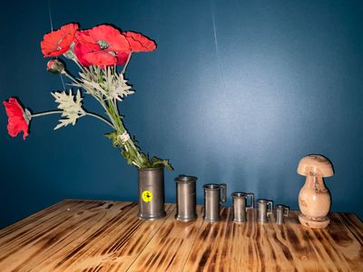 a vase with red flowers in it on a wooden table
