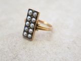 Gros plan sur une bague en or ornée de perles