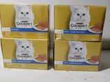 quatre boîtes de nourriture pour chat haut de gamme posées sur une table