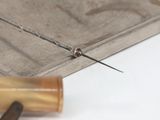 a close up of a pair of scissors on a piece of wood