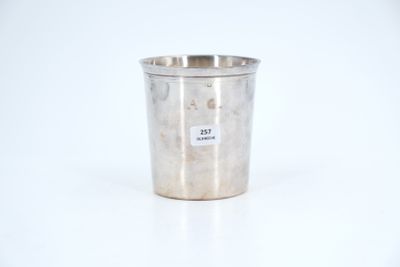 an old silver cup sitting on a white surface with a sticker on it