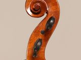a close up of the back of a violin with a fiddle in the foreground