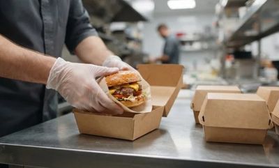 un homme qui tient un hamburger dans une boîte