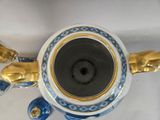 a blue and white vase with gold decorations on it