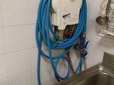 un tuyau bleu fixé au mur à côté d'un évier