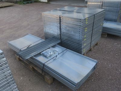 plusieurs piles de tôles d'acier empilées les unes sur les autres sur une palette