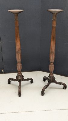 paire de bougeoirs anciens en bois sur des socles en fonte