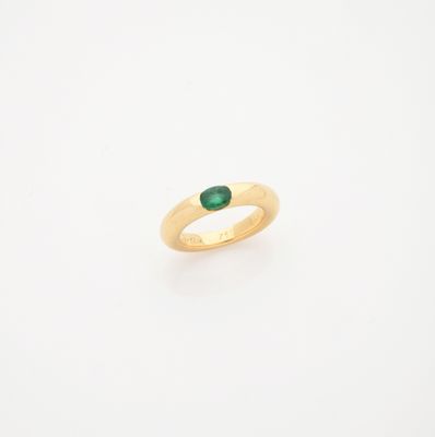 une bague en or avec une pierre verte au centre