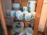 a wooden cabinet with dishes and cups on it