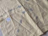 two pieces of cloth on a bed with a tag on it