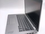 a silver laptop with a black keyboard on a white surface