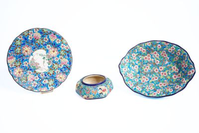 trois compositions florales bleues et roses sur une assiette et un bol