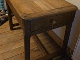 a small wooden table with a drawer on top of it