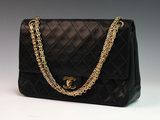 a black chanel bag with gold chains on a white background