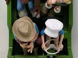 a green toy truck with a bunch of figurines in it