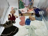 a display case filled with dolls and clothes on a table