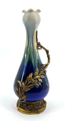 a blue and white vase with a gold decoration on it